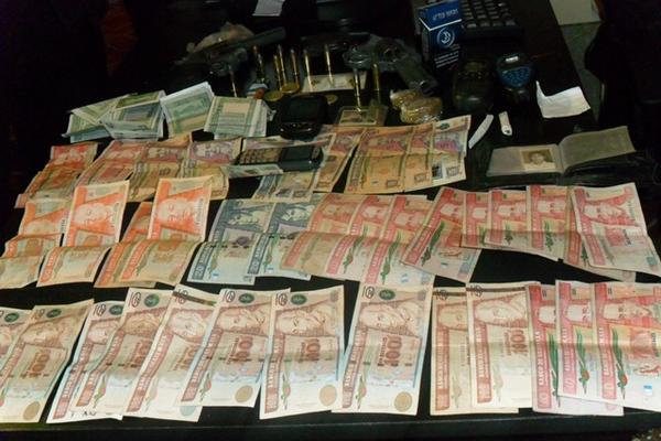 Dinero, armas y celulares incautados a los detenidos. (Foto Prensa Libre: Angel Julajuj)<br _mce_bogus="1"/>