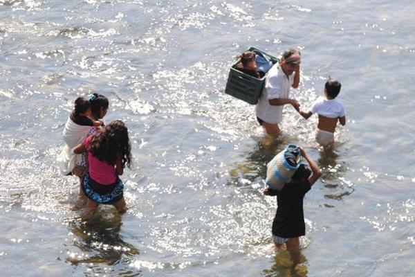 Familias completas, padres y sus hijos menores cruzan el río Suchiate en la frontera El Carmen- Talismán. (Foto Prensa Libre: Edgar Girón)