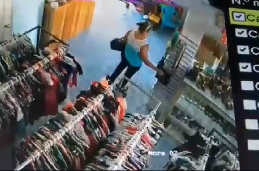 Mujer es filmada cuando extrae un teléfono móvil de la cartera de una mujer en El Chal, Petén. (Foto Prensa Libre: Imagen de Facebook El no nos tientes petenero)
