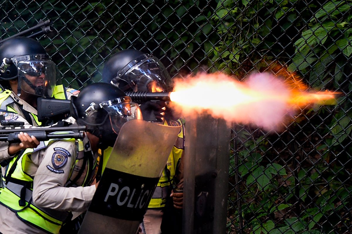 Policías lanzan gases lacrimógenos contra manifestantes en Venezuela. (Foto Prensa Libre: AFP)