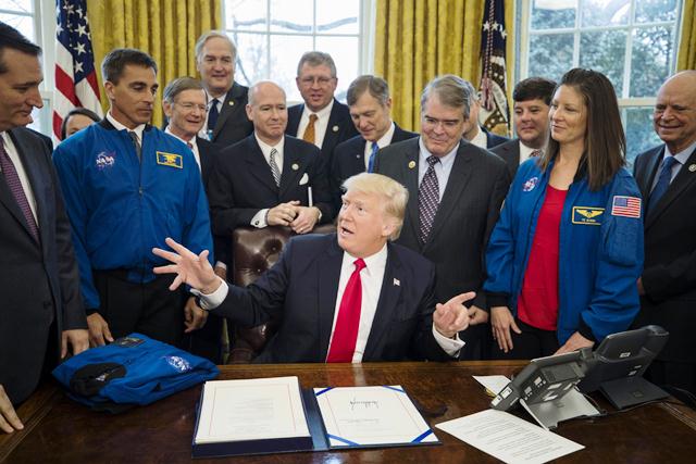 Donald Trump unto a funcionarios de la NASA en la firma de la ley que aprueba fondos. (Foto Prensa Libre: EFE)