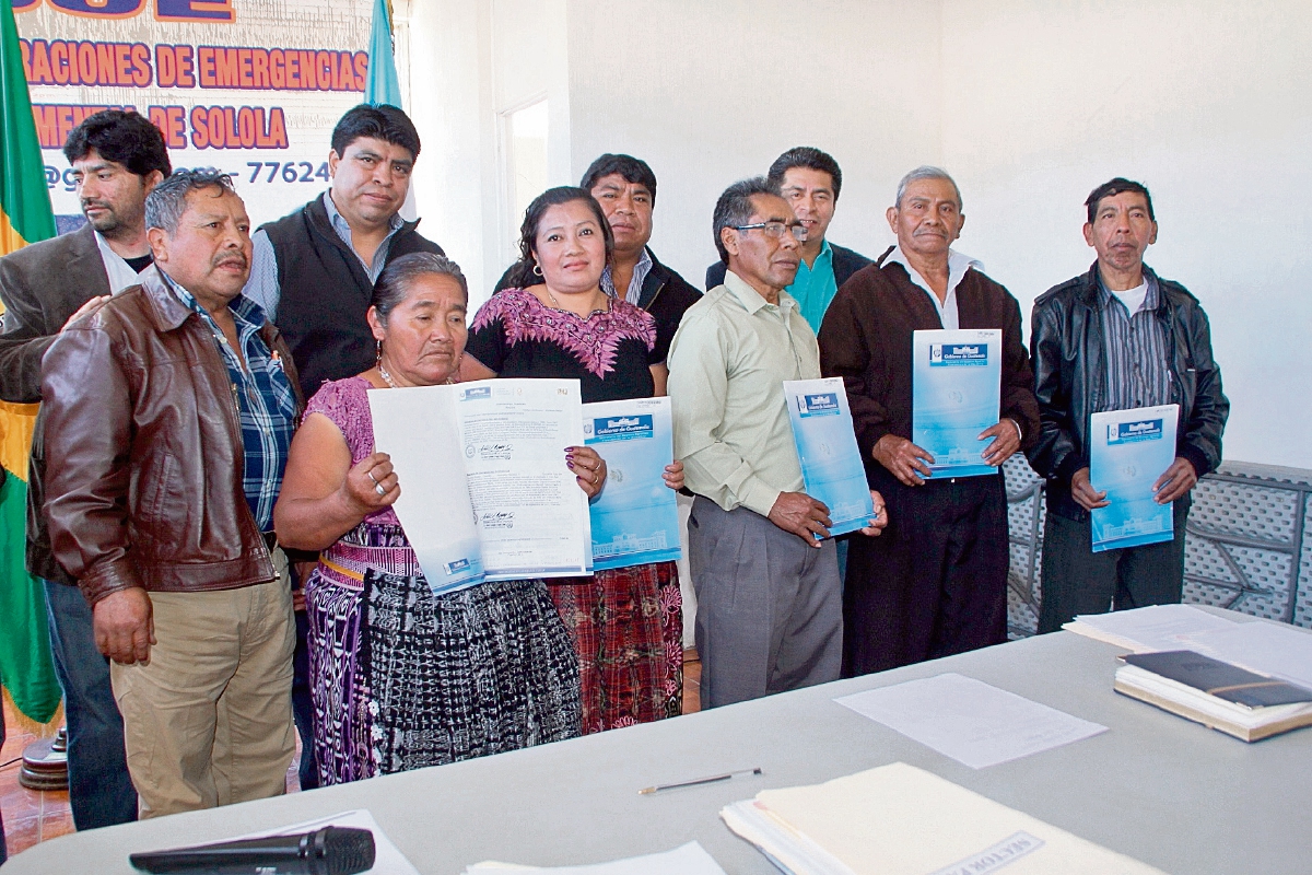 Algunos de  los beneficiados muestran la escritura de su terreno en San Juan La Laguna.