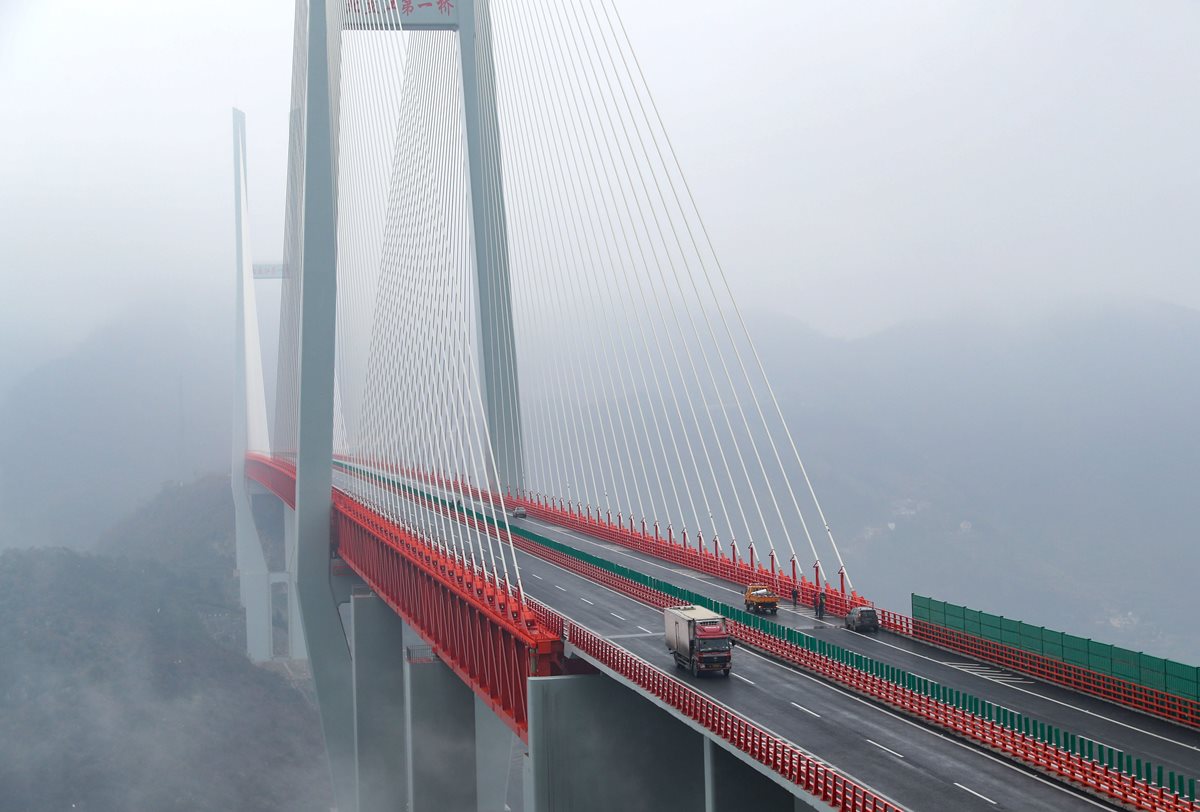 Un camión cruza el puente Beipanjiang ubicado en el sureste chino, el que está construido a mayor altura en todo el mundo. (Foto Prensa Libre: AFP).
