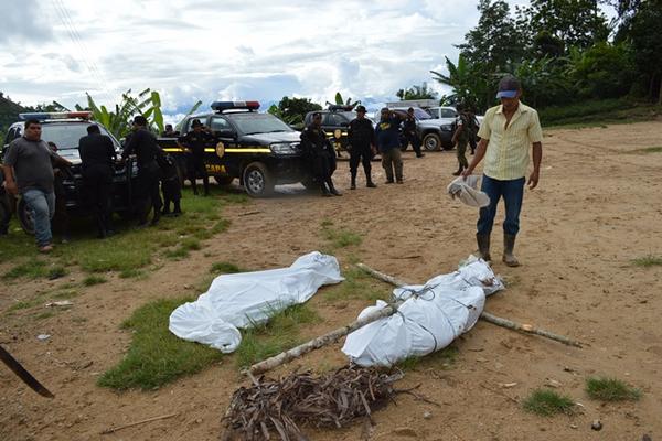 Familiares y policías observan los cadáveres de campesinos. (Foto Prensa Libre: Edwin Paxtor)<br _mce_bogus="1"/>