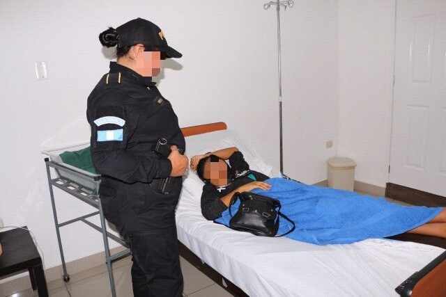 Agente de la PNC custodia a Verónica Lima, madre de la bebé. (Foto Prensa Libre: PNC).