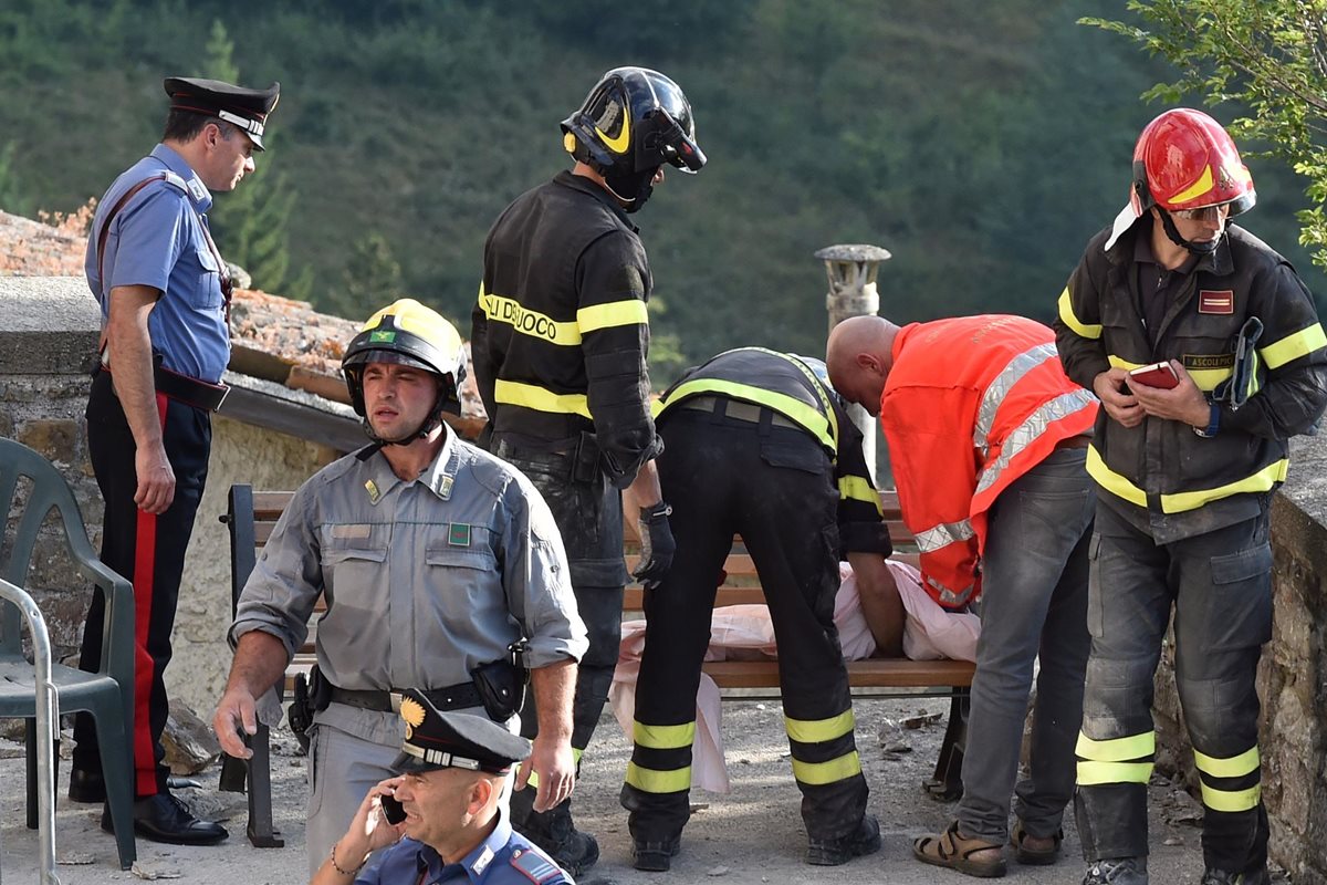 Los bomberos rescatan el cadáver de una niña, víctima del terremoto, en Arquata del Tronto, Italia. (Foto Prensa Libre: AFP).