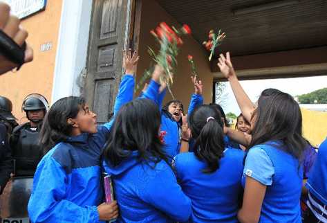 Un grupo de estudiantes del instituto Belén lanzan claveles rojos al aire, al anunciar el acuerdo alcanzado con el Mineduc para entregar el plantel.