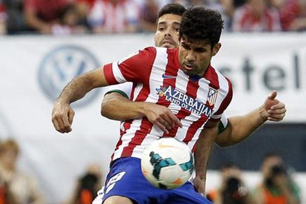 El delantero del Atlético de Madrid, Diego Costa, controla el balón ante el defensa del Elche, Alberto Botía. (Foto Prensa Libre: EFE)
