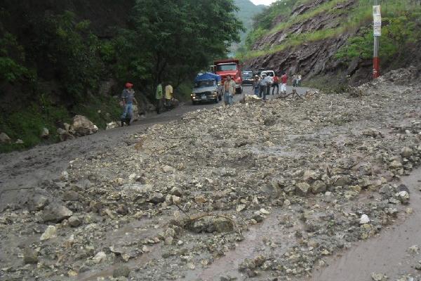 Lodo y piedras bloquean  carretera.