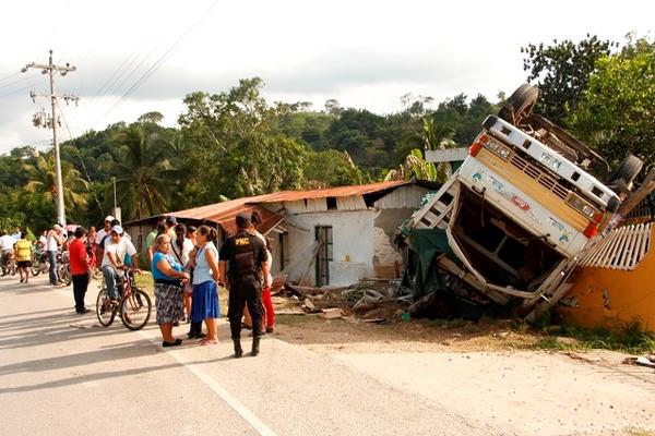 Vecinos del barrio La Ceibita, Melchor de Mencos, observan el camión  volcado que transportaba mercadería de contrabando. (Foto Prensa Libre:  PNC)