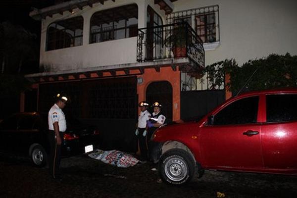 Socorristas observan el cadáver del fontanero José Manuel Rodríguez Mayen, quien murió baleado cuando salía de la vivienda del secretario departamental del PP en Sacatepéquez. (Foto Prensa Libre: Miguel A. López)