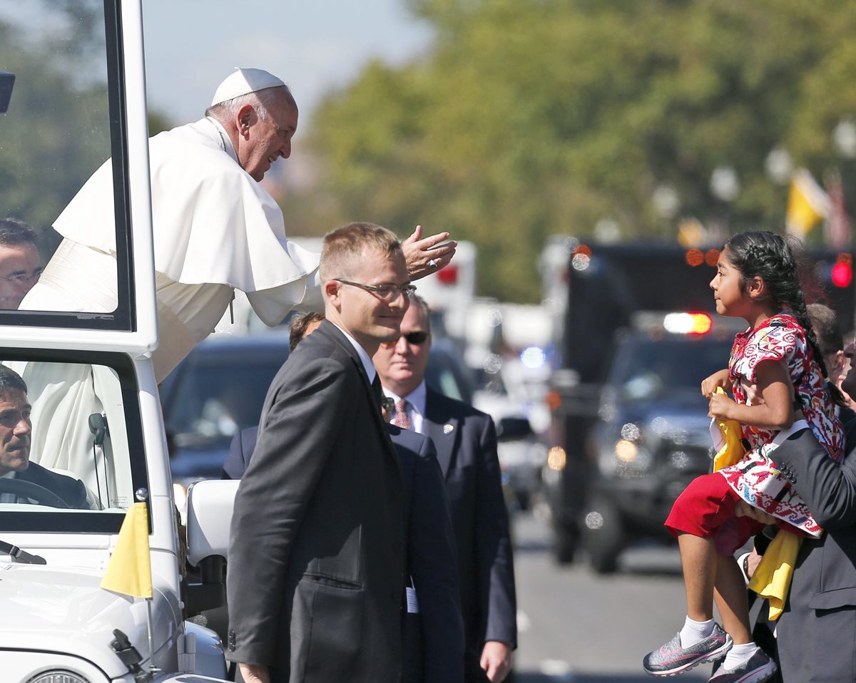 Sophie Cruz es llevada en brazos por un agente de seguridad para que salude al Papa. (Foto Prensa Libre: AP).