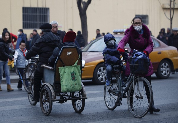 Una madre y su hijo usan mascarillas para protegerse de la contaminación en Pekín, China. (Foto Prensa Libre: EFE)