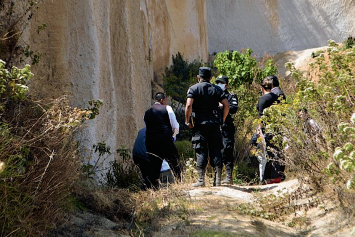 Fiscales del MP inspeccionan lugar donde encontraron el cadáver de un migrante hondureño, en Concepción Chiquirichapa, Quetzaltenango. (Foto Prensa Libre: Carlos Ventura)
