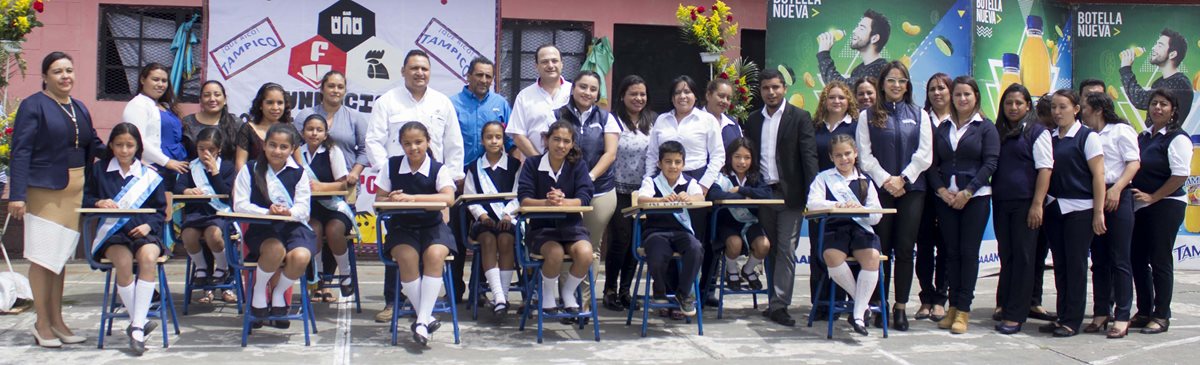 Ejecutivos de Tampico y la Fundación acompañados de los docentes y estudiantes beneficiados de la Escuela Oficial Rural Mixta El Patrocinio, en el municipio de San Vicente Pacaya. (Foto Prensa Libre: EFE)