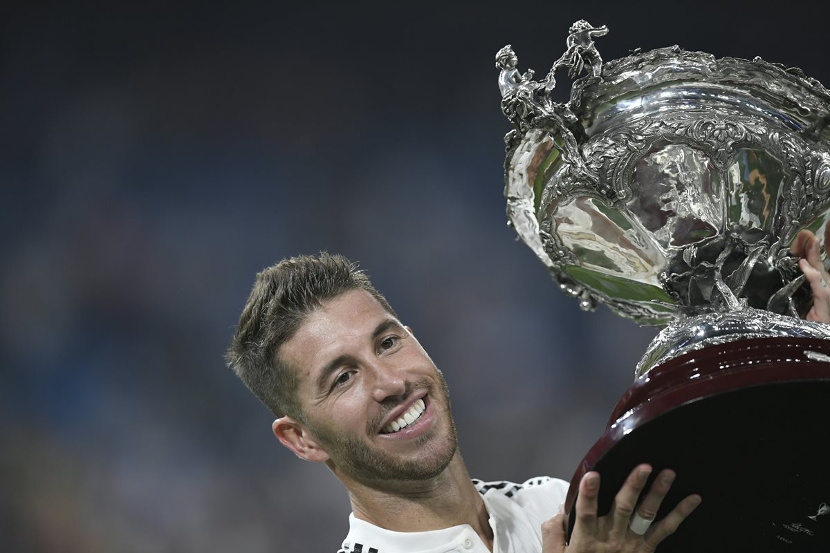 El defensa del Real Madrid Sergio Ramos, alza el trofeo Santiago Bernabéu, que el equipo merengue ganó este sábado. (Foto Prensa Libre: AFP)
