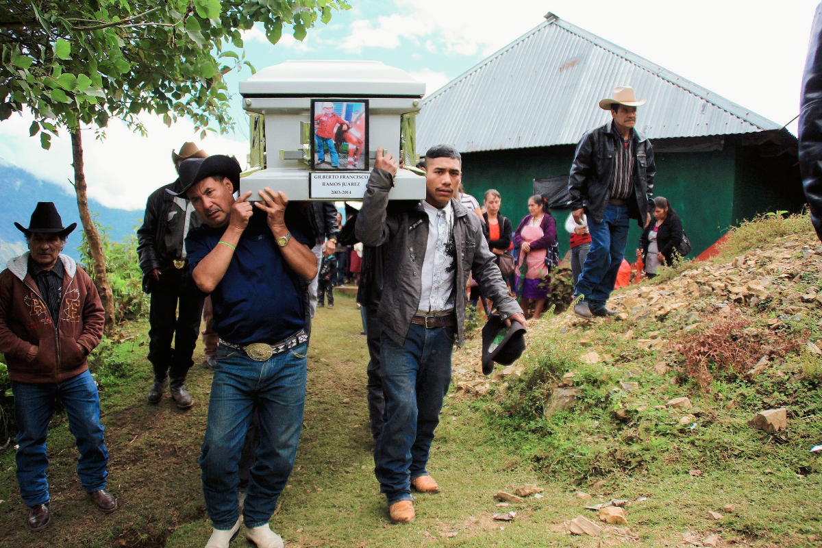 Pobladores de Chiantla, Huehuetenango, llevan en hombros el ataúd con el cuerpo del menor Gilberto Ramos, para inhumarlos en el cementerio de ese municipio. (Foto Prensa Libre : Mike Castillo)