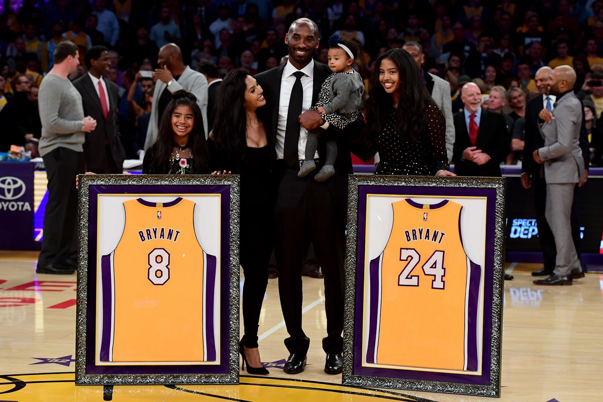 Kobe Bryant posó junto a su familia con las dos camisolas que tienen los números 8 y 24 que fueron retirados por los Lakers. (Foto Prensa Libre: AFP)