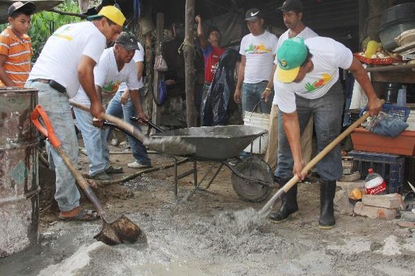 Trabajadores de la comuna de Tecún Umán colocan torta de cemento en   una vivienda.