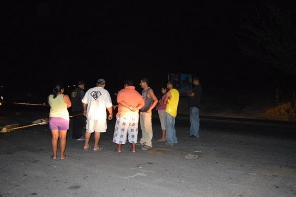 Vecinos observan el lugar donde murió atropellado Carlos Fernando Zacarías, en Río Hondo. (Foto Prensa Libre: Víctor Gómez)