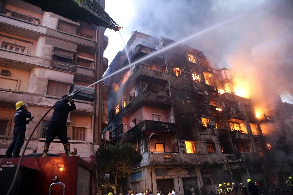 Bomberos extinguen el fuego en la zona de un centro comercial en El Cairo. (AFP)