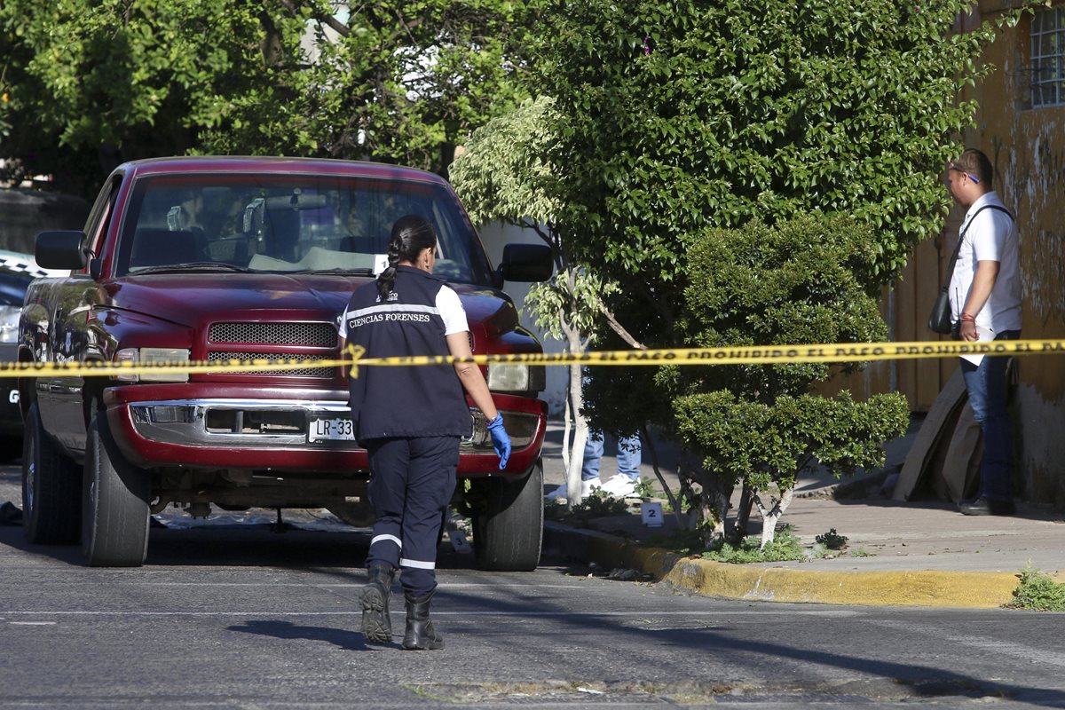 Peritos forenses inspeccionan el vehículo donde fueron hallados los cuerpos de varias personas en la ciudad de Guadalajara, México. (Foto Prensa Libre: EFE)
