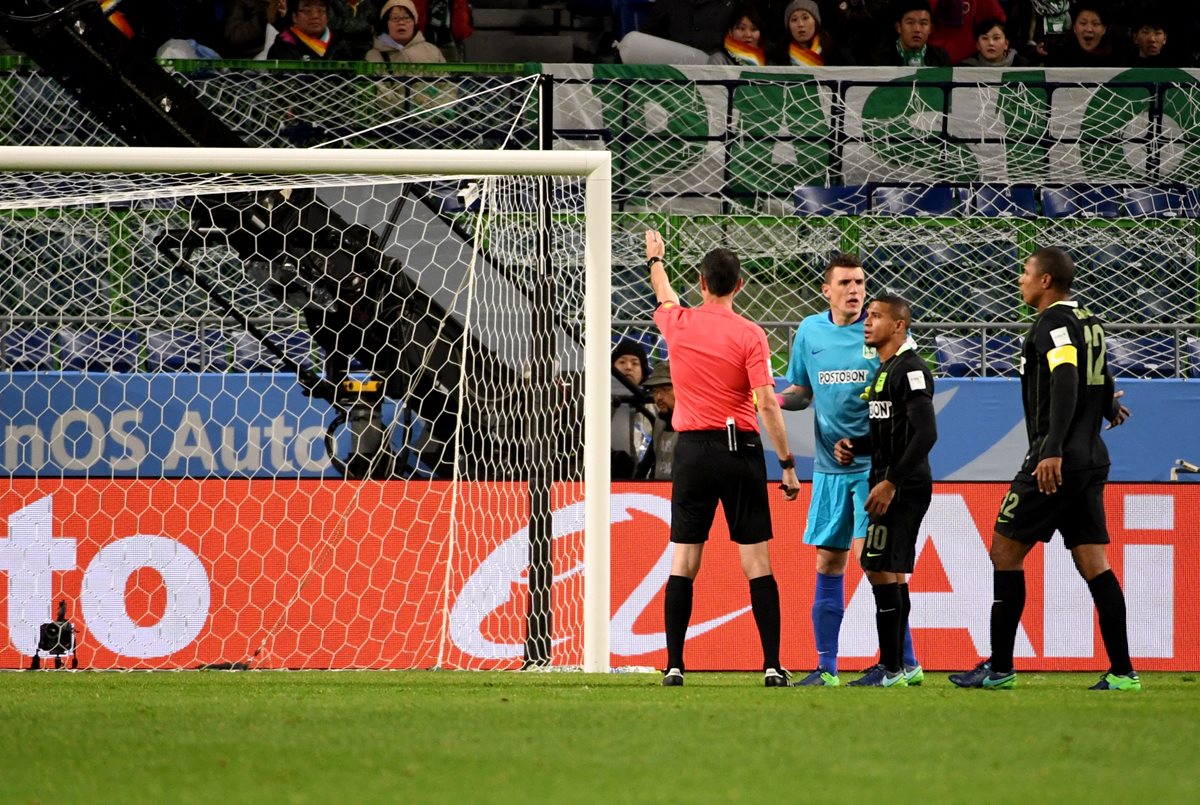 El árbitro decreta el penalti luego de comunicarse con el árbitro asistente de video. (Foto Prensa Libre: AFP)