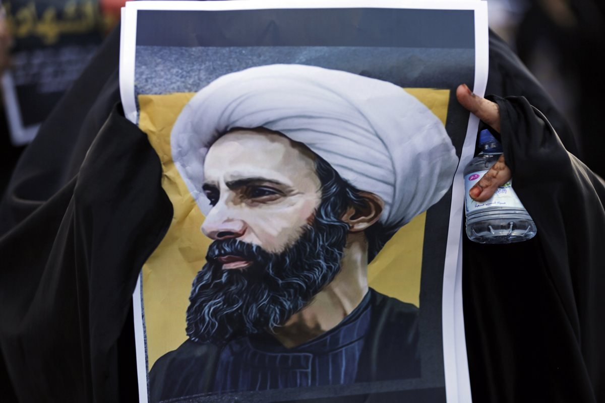 Un maniestante en Baréin sostiene una imagen del fallecido líder chií saudí, Sheikh Nimr al- Nimr. (Foto Prensa Libre: AP).