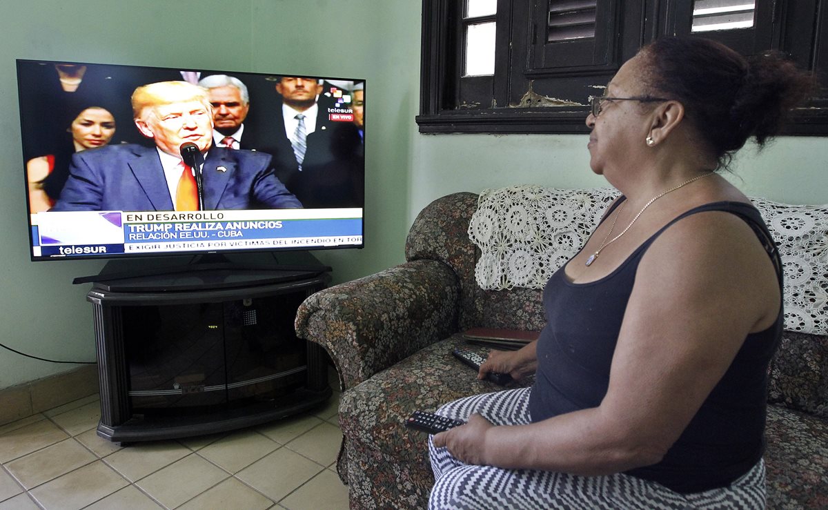 Una cubana escucha la declaración del presidente Donald Trump, en la que este anunció el endurecimiento de nomas a ese país. (Foto Prensa Libre: EFE)
