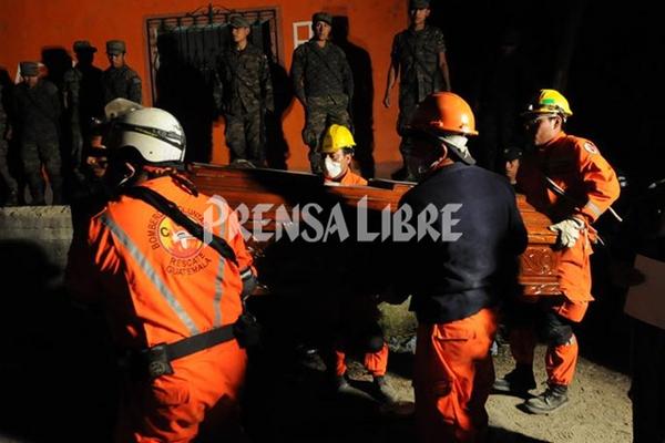Bomberos rescatan cadáver del obrero soterrado. (Foto Prensa Libre: Aroldo Marroquín)