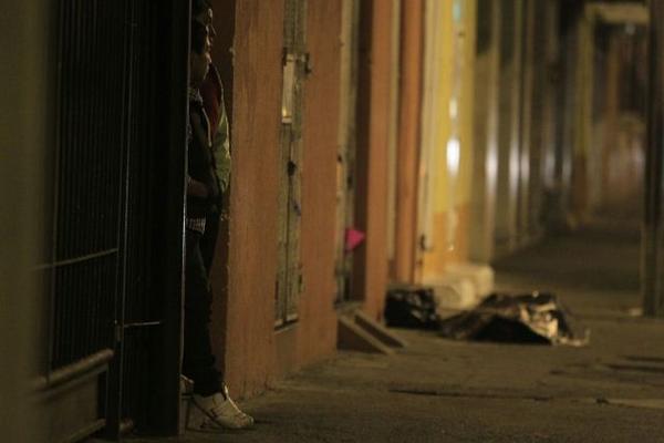 Vecinos observan el cadáver de la mujer, muerta a balazos en el Parque Colón, zona 1. (Foto Prensa Libre: Edwin Bercian)