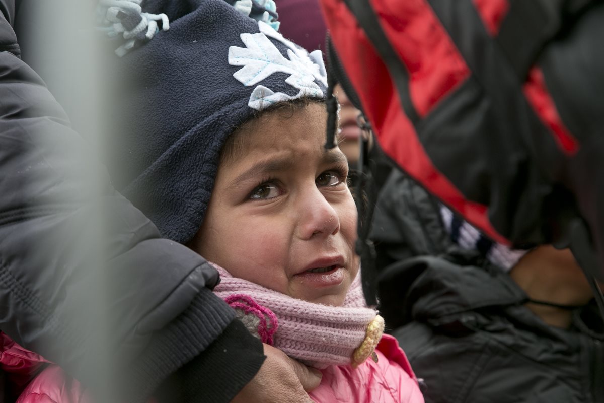 Una niña migrante llora en la frontera con Macedonia en Serbia, en su ruta hacia Europa. (Foto Prensa Libre: AP).