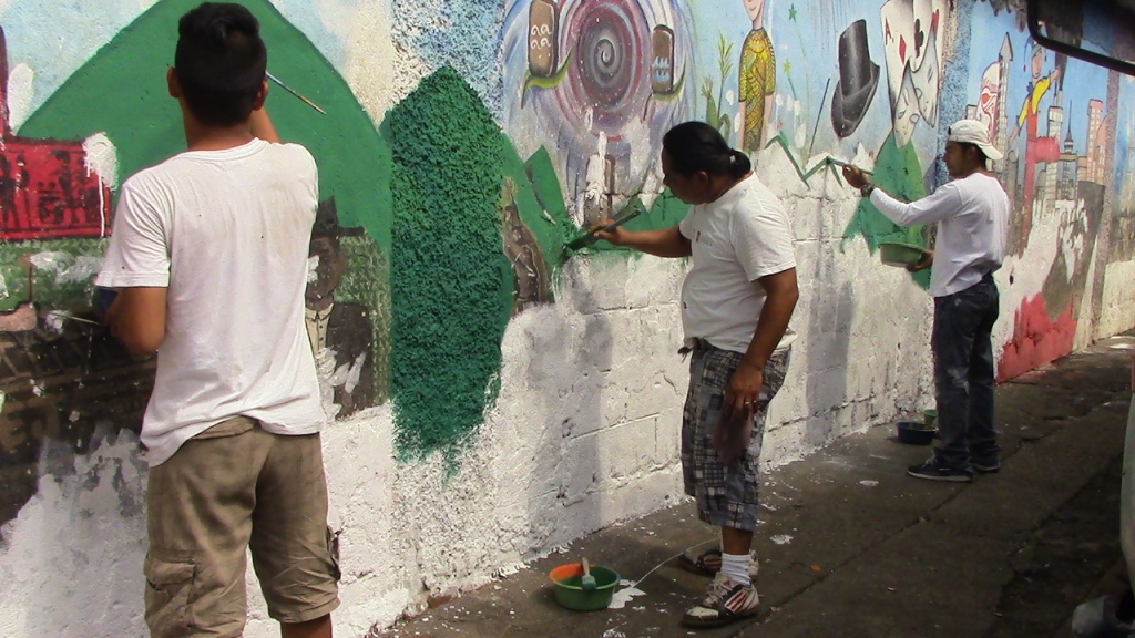 Jóvenes trabajan en la parte inferior del mural del Centro de Arte y Cultura de Mazatenango. (Foto Prensa Libre: Melvin Popá).