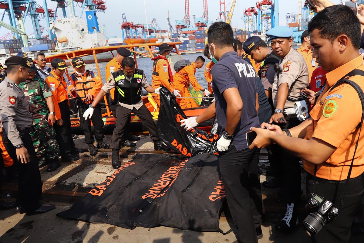 Socorristas rescatan los primeros cuerpos de las víctimas del accidente aéreo. (Foto Prensa Libre: AFP)