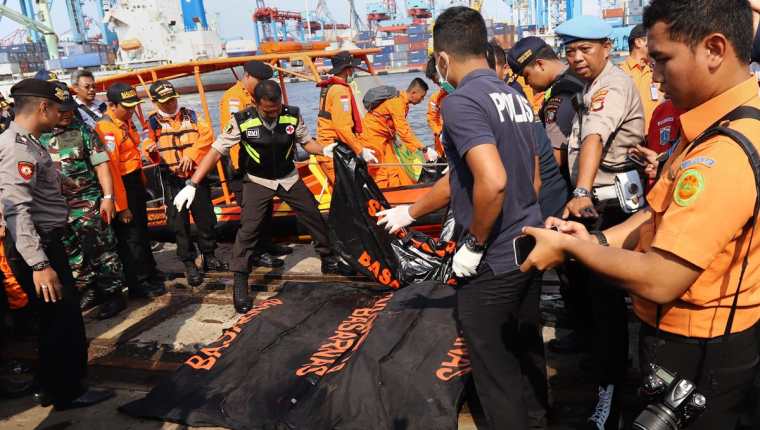 Socorristas rescatan los primeros cuerpos de las víctimas del accidente aéreo. (Foto Prensa Libre: AFP)