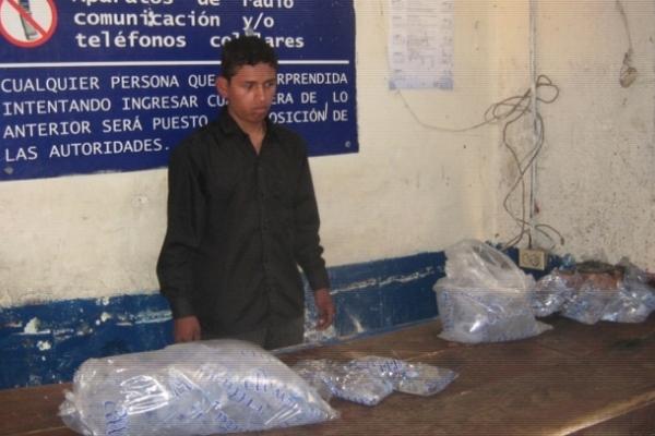 Héctor Leonardo Suyún Choc fue sorprendido cuando intentaba ingresar licor en bolsas de agua pura a la cárcel de Cobán. (Foto Prensa Libre: PNC)