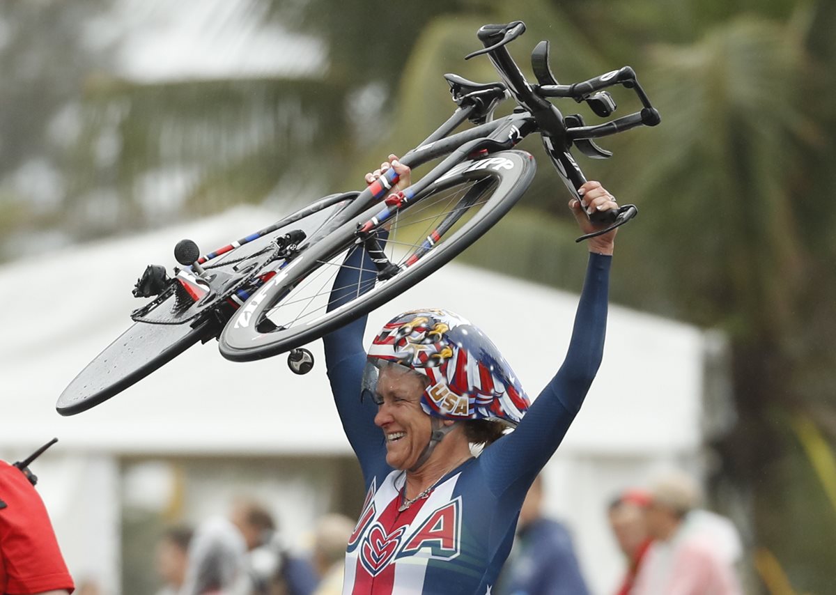 Kristin Armstrong levanta su bicicleta en señal de victoria luego de ingresar a la meta. (Foto Prensa Libre: AP)