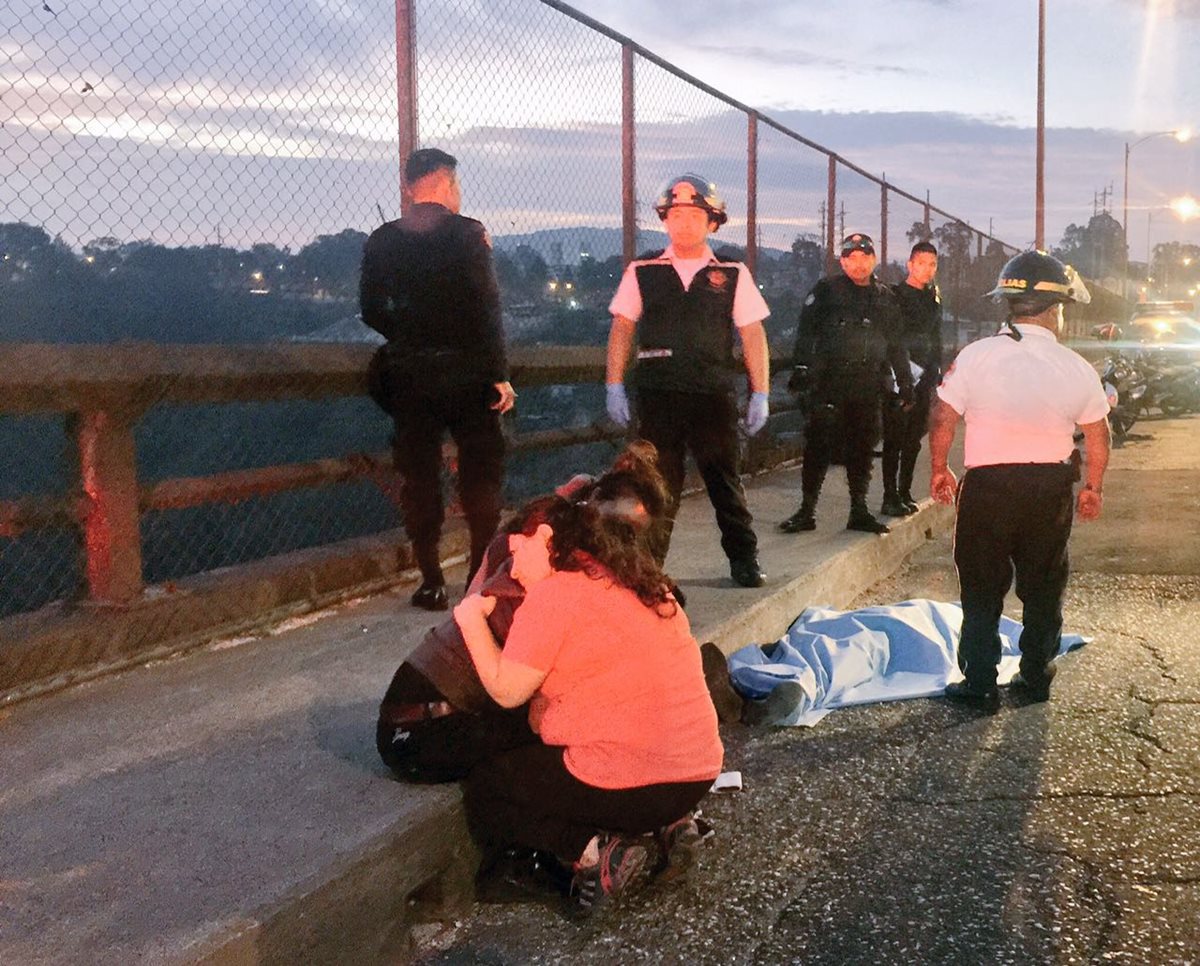 Familiares del presunto delincuente lamentan su muerte en el puente El Incienso, zona 3. (Foto Prensa Libre: Cortesía CVB).