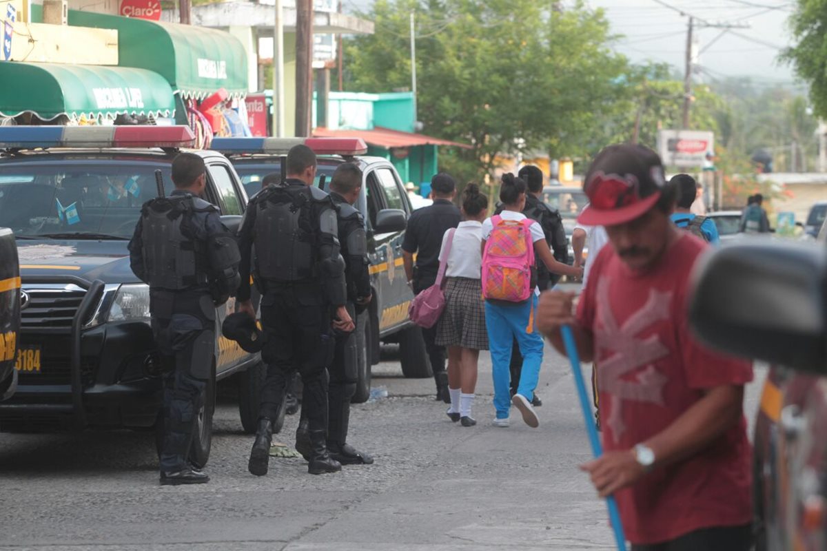 La PNC patrulla el municipio de San José del Golfo, mientras personas limpian los escombros que quedan del enfrentamiento. (Foto Prensa Libre: Érick Ávila)