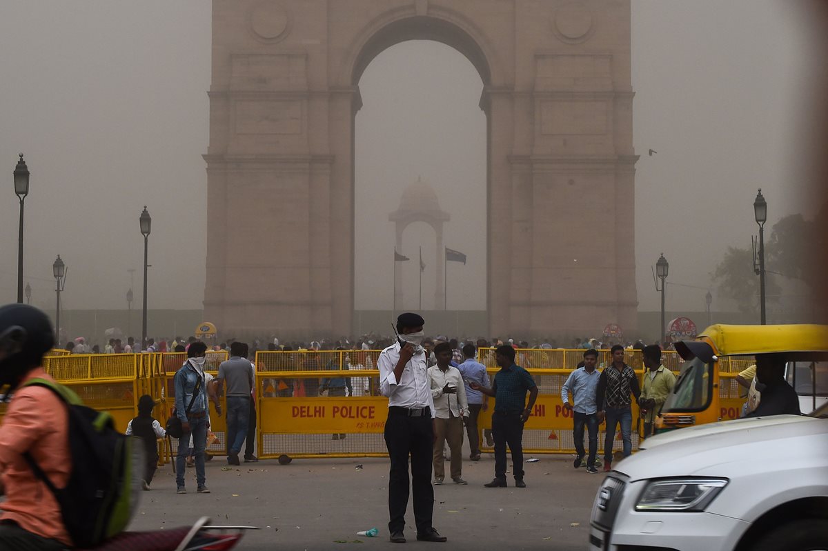 Un policía de tránsito indio se cubre la cara mientras está de servicio durante una tormenta de polvo en Nueva Delhi.(Foto Prensa Libre:AFP).