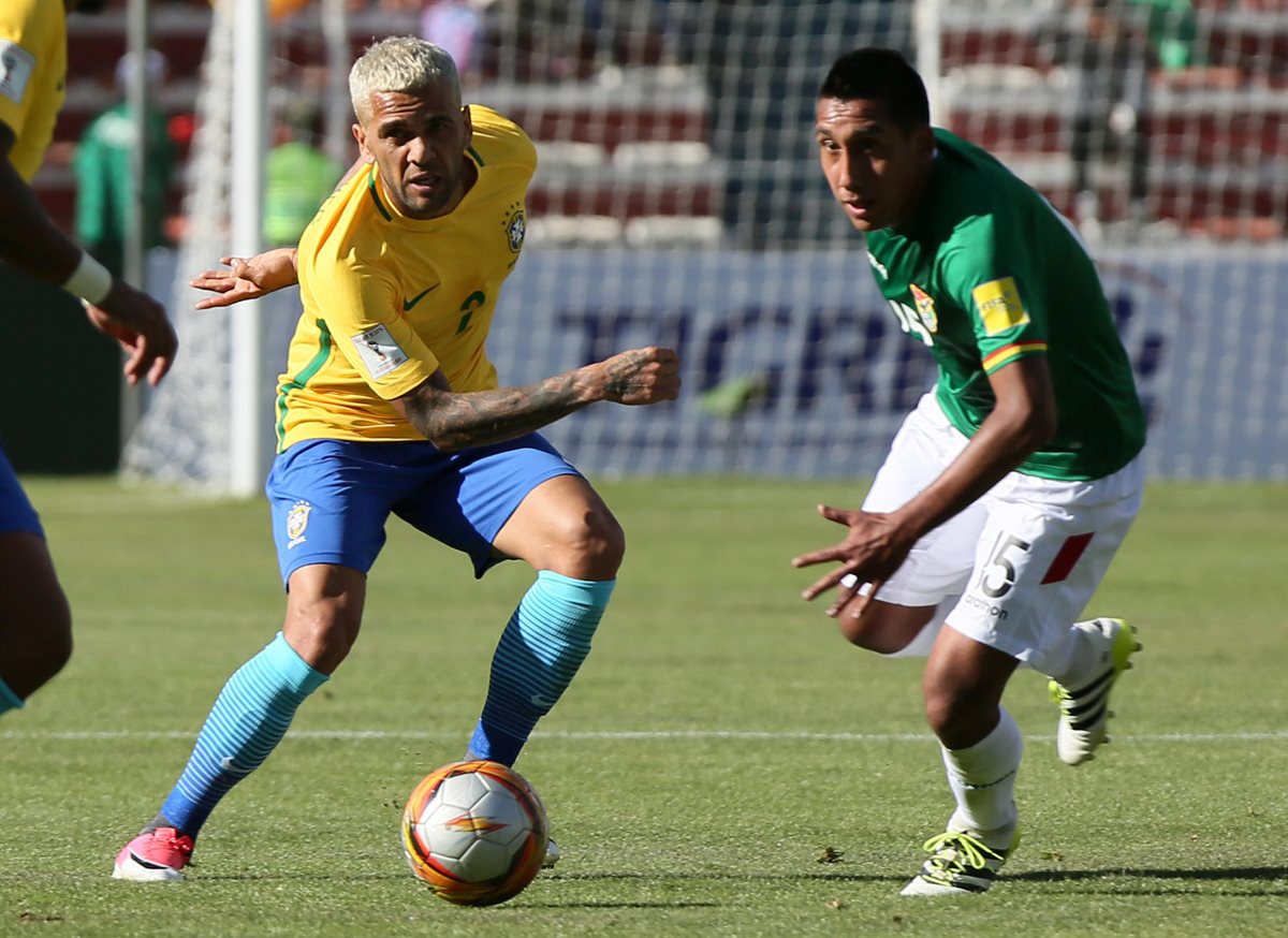El boliviano Cristian Machado (d) disputa el balón con Dani Alves (i) de Brasil. (Foto Prensa Libre: EFE)