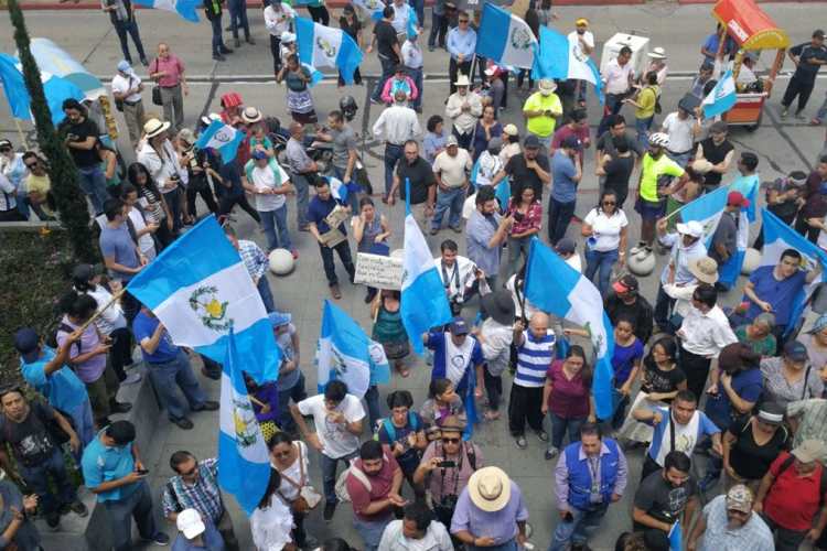 Las banderas de Guatemala se pueden apreciar en las afueras de la CC durante la manifestación.
