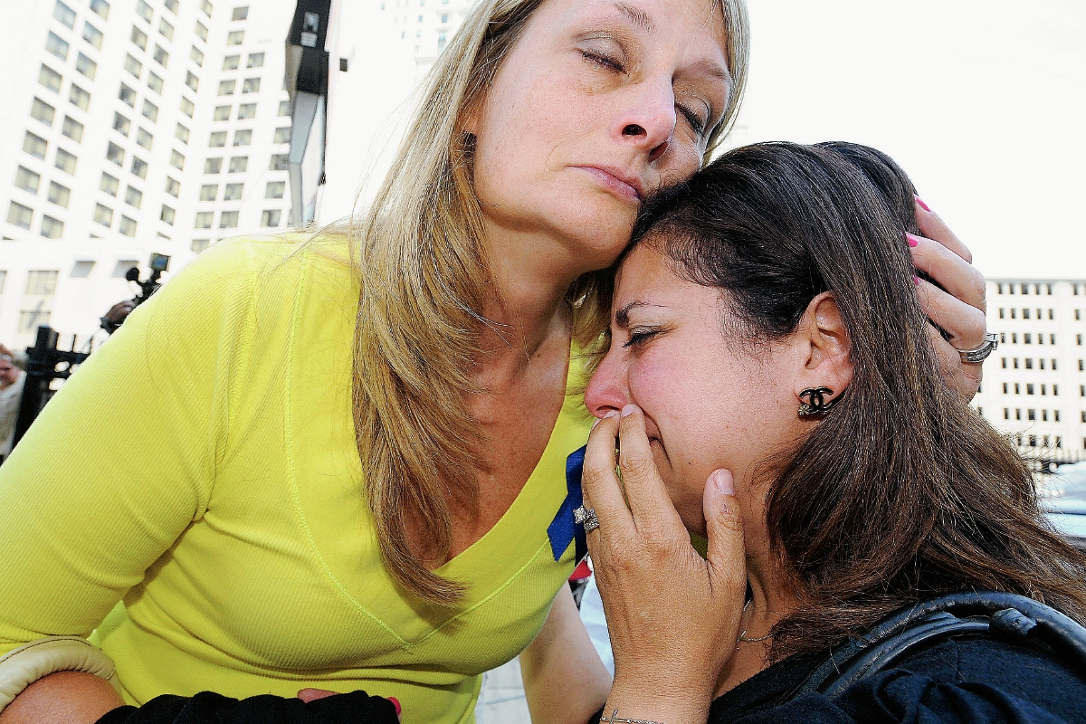Cheryl Blades, izquierda, abraza a una señora que acudió al juicio y que llora tras la sentencia. La señora, de negro, no identificada afirmó que mientras estuvo embarazada recibió tratamientos contra el cáncer que no necesitaba. (Foto Prensa Libre: AP).
