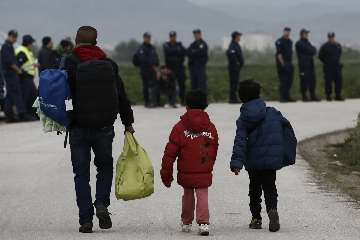 Refugiados trasladan sus pertenencias durante la operación de la policía griega para desalojar el campamento improvisado de Idomeni. (Foto Prensa Libre: EFE).