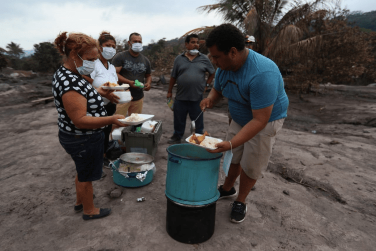 Raciones de comida son repartidas a voluntarios en la zona cero, donde continúan la excavaciones.