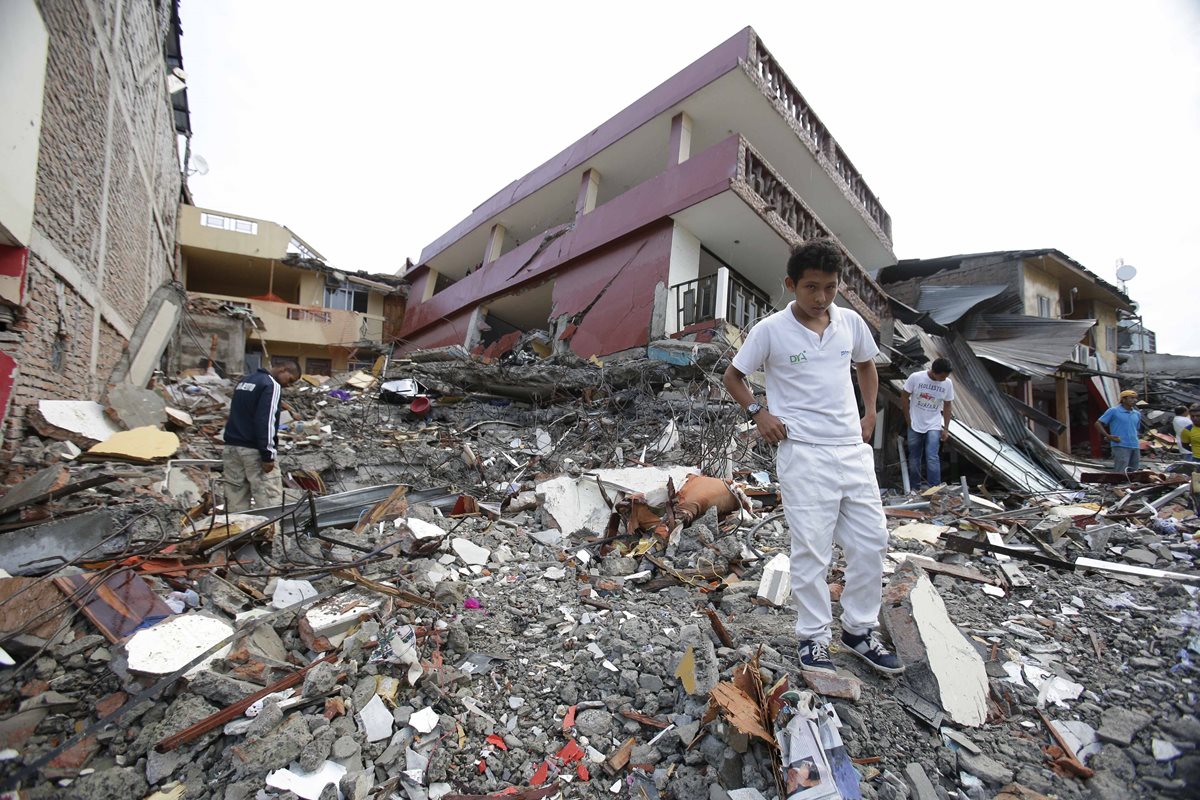Un sobreviviente camina entre los escrombros en Pedernales, una de las zonas más devastadas por el potente terremoto. (Foto Prensa Libre: AP).