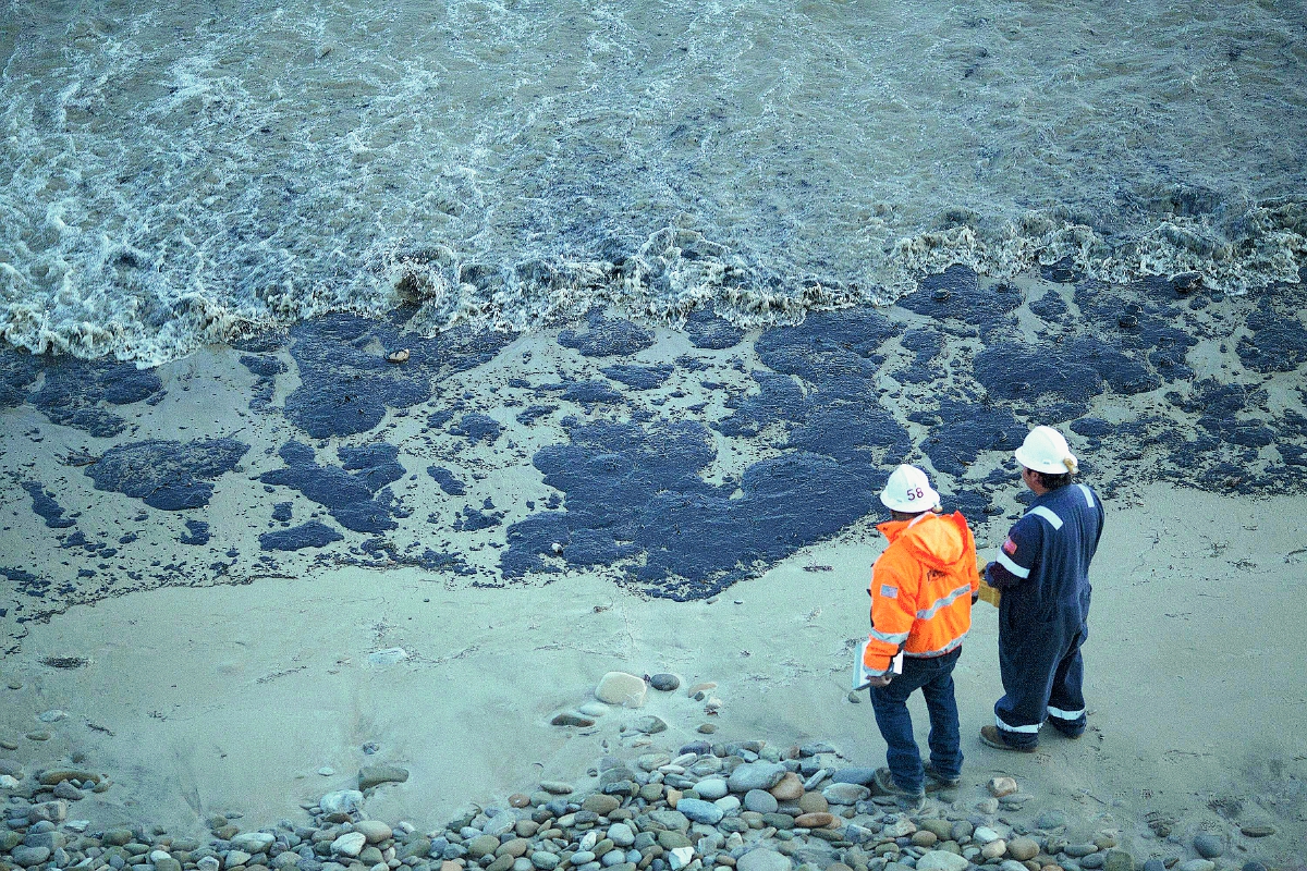 Los funcionarios caminan por una playa cubierta de petróleo al norte de Goleta, California. (Foto Prensa Libre:AP