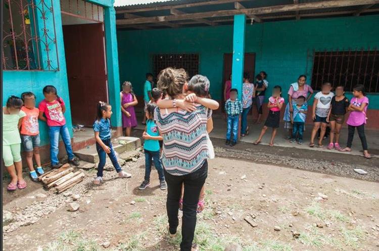 Una maestra abraza a Dayananci en el primer día de clases de la pequeña. La menor originaria de San Marcos estuvo separada de sus padres por varios meses y sufrió para adaptarse de nuevo. (Foto Prensa Libre: Hemeroteca PL)