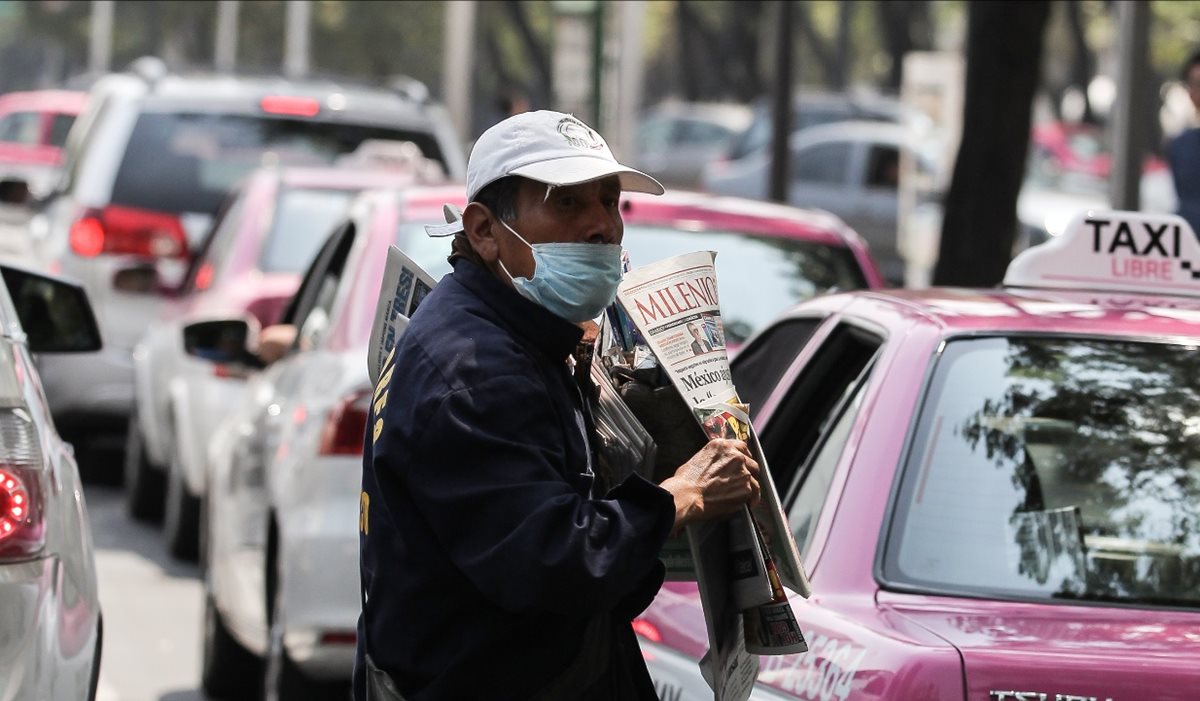 Un vendedor de prensa usa tapabocas como medida por la mala calidad del aire.(EFE).
