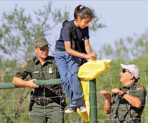 Agentes de la Patrulla Fronteriza ayudan a una niña a cruzar la malla que divide México y EE. UU. (Foto:diaadianews.com). (Foto Prensa Libre: AP)
